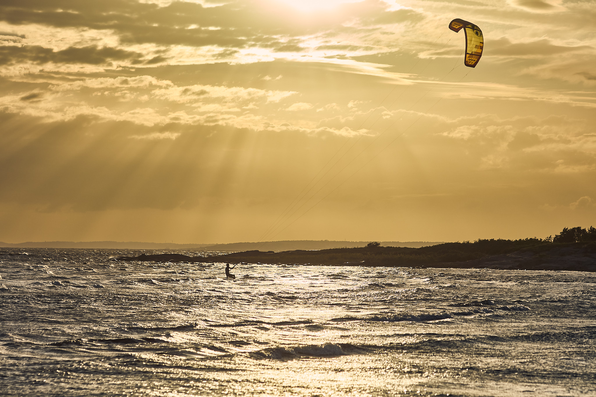 Kitesurfare i motljus, västkusten