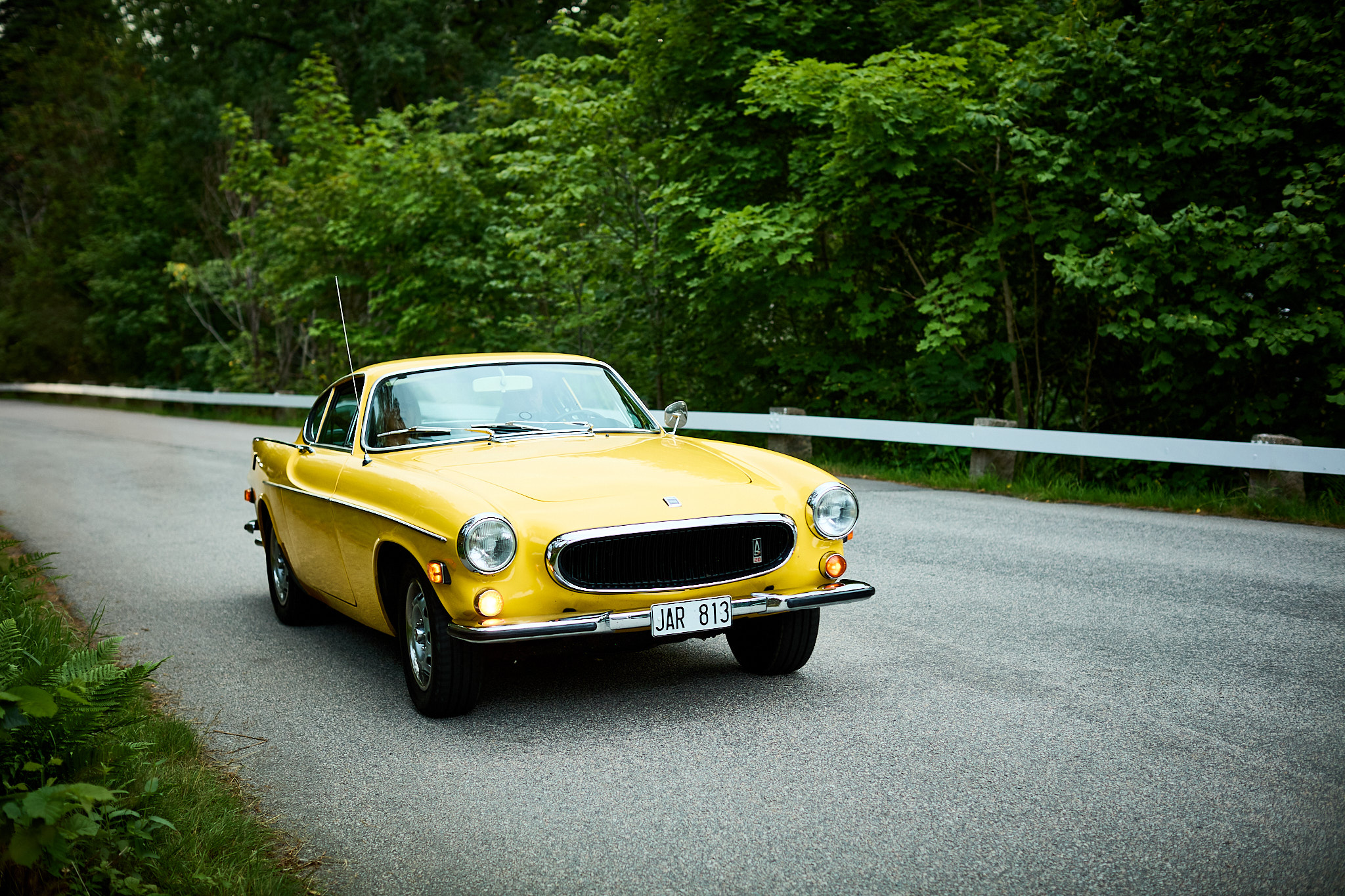 Gul Volvo P1800 på landsväg